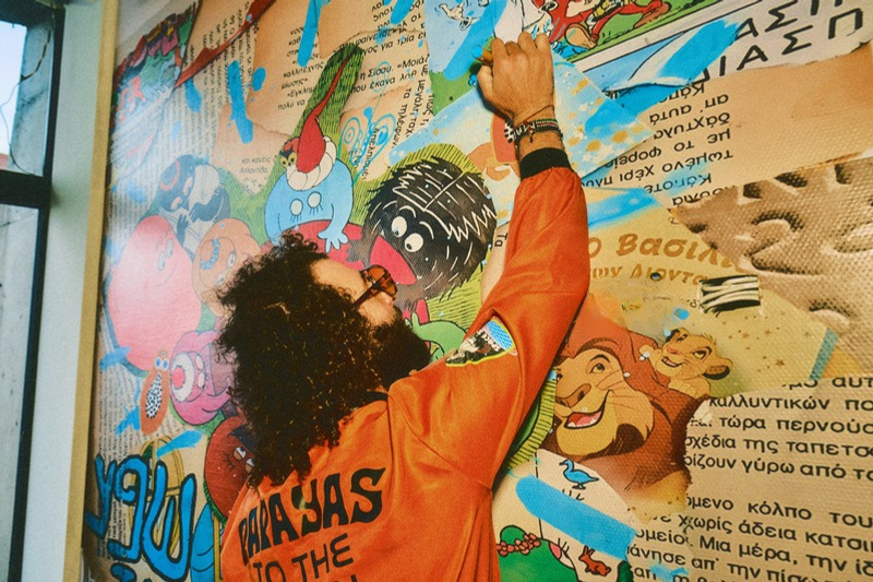 Alejandro painting a monumental collage mural