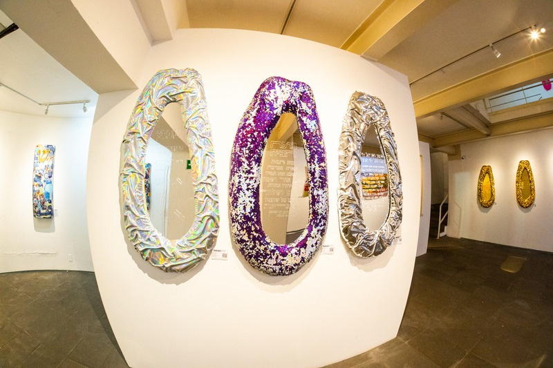 Three metallic papaya sculptures in gallery