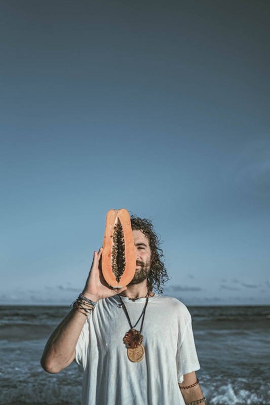 Alejandro Glatt with papaya on the beach