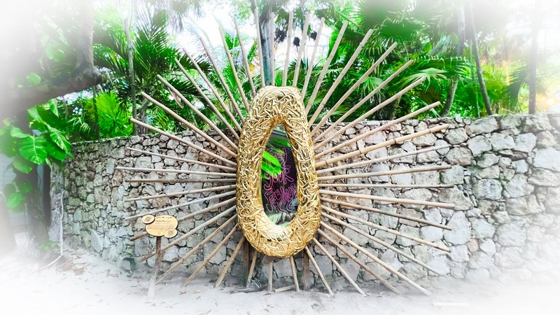 Golden papaya sculpture against stone wall in jungle